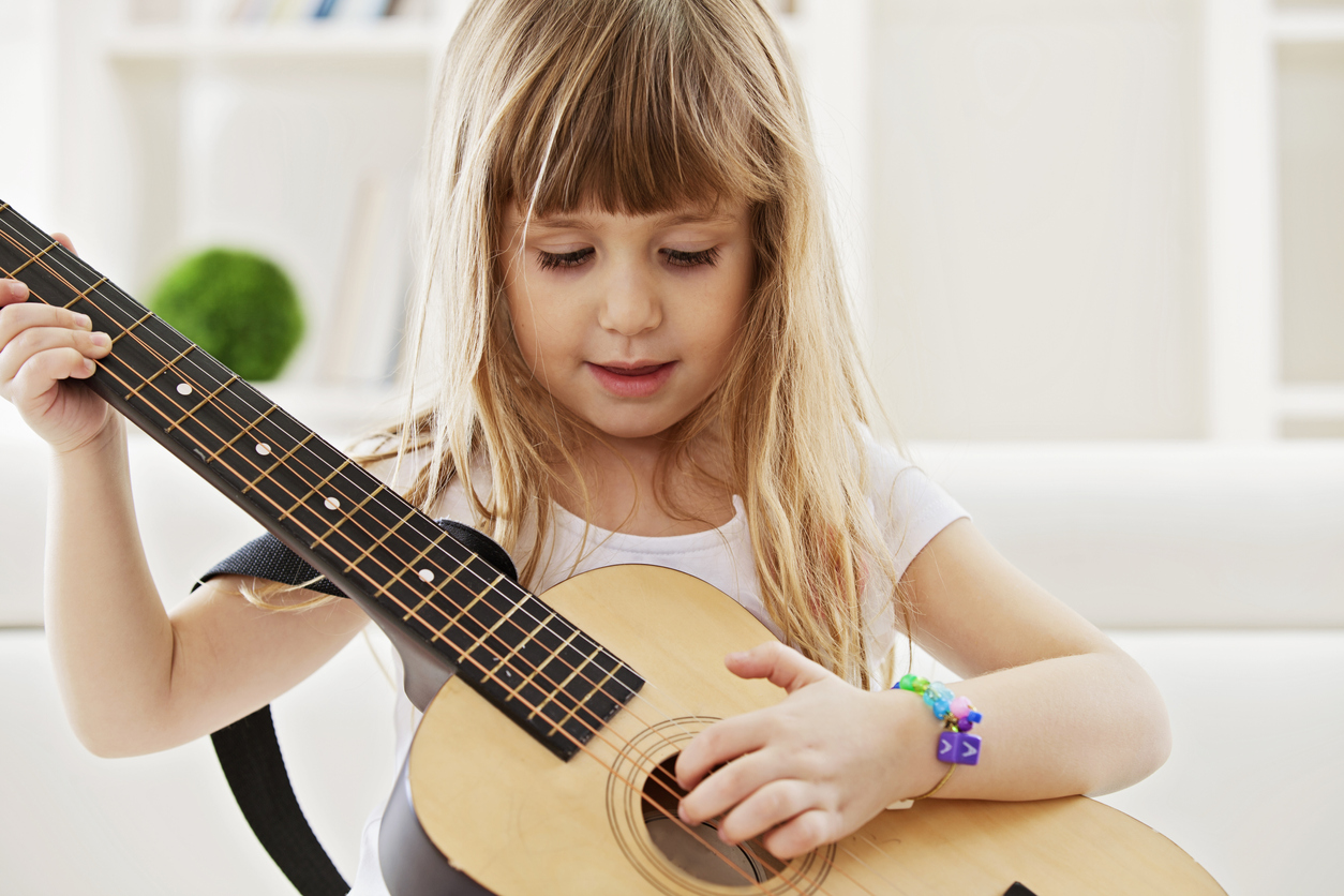 Little Girl Playing Guitar At Home