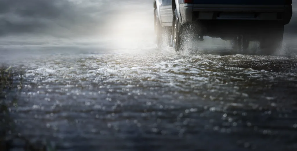 Car Run Through Flood Water After Hard Rain With Water Spray From The Wheels.