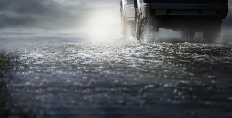 Car Run Through Flood Water After Hard Rain With Water Spray From The Wheels.